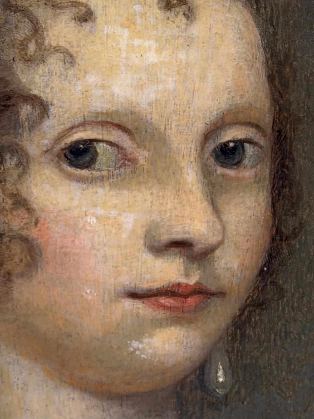 A 17th-century oil portrait painting on an oak panel depicting a woman with dark ringlets and pearl jewellery in a gadrooned gold leaf frame. View IX