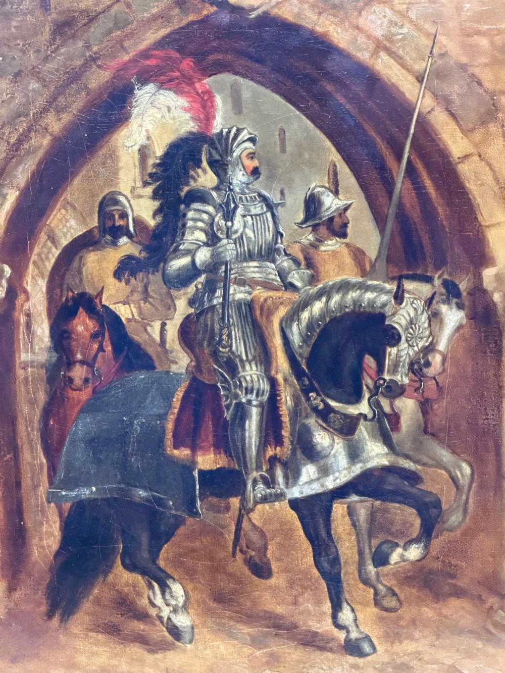 An antique oil painting depicting a knight in full armour riding a horse beneath a stone archway, framed in an ornate gilded wood frame. View IV