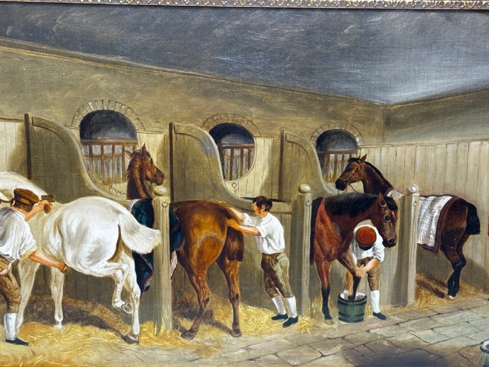 A horizontal oil painting depicting grooms tending to horses inside a stable block, housed within a fluted gilt wood frame. View VI