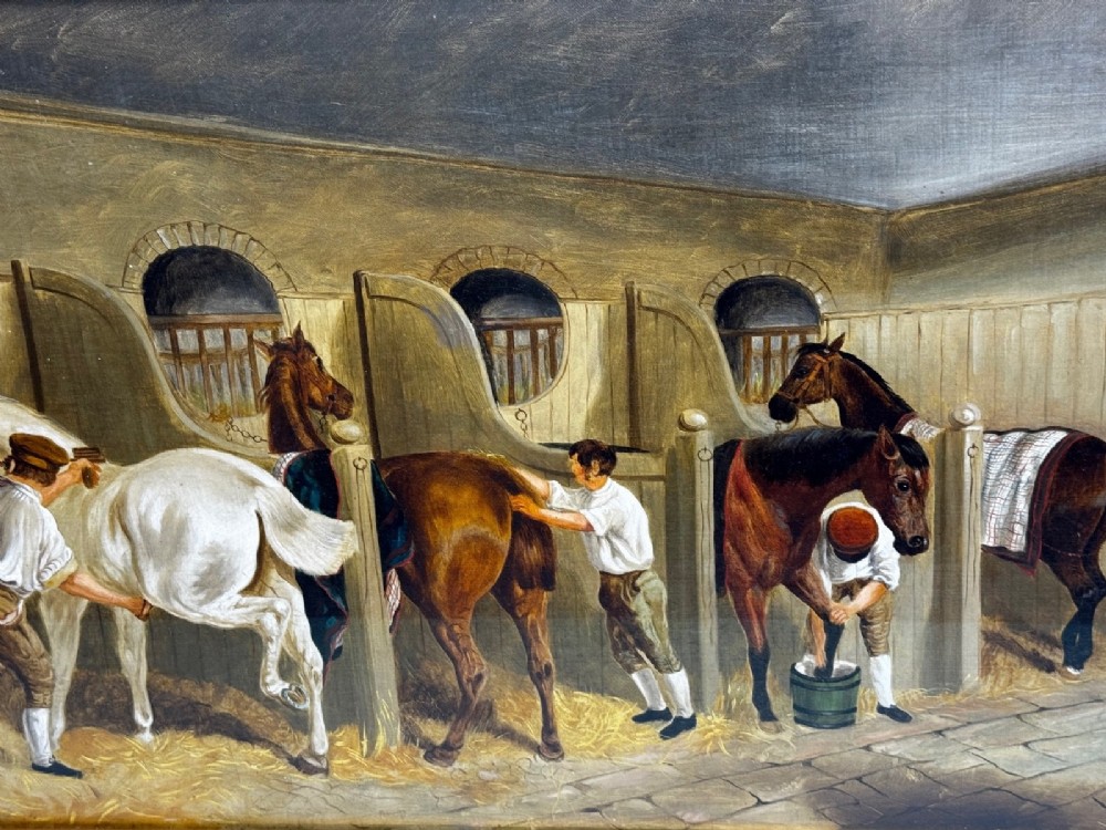 A horizontal oil painting depicting grooms tending to horses inside a stable block, housed within a fluted gilt wood frame. View XIV