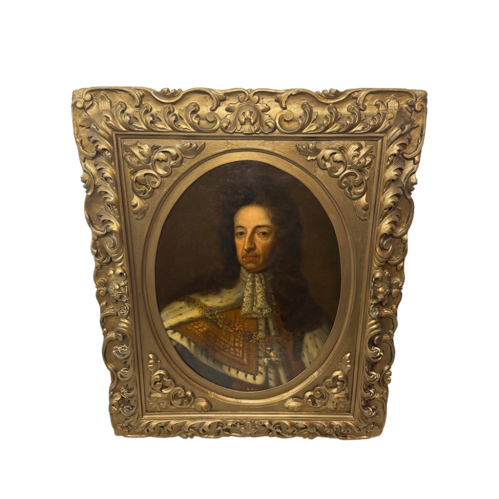 An 18th-century oil painting depicting King William III in a curled wig and ermine cloak, set within an oval aperture inside an ornate rectangular gold carved frame.