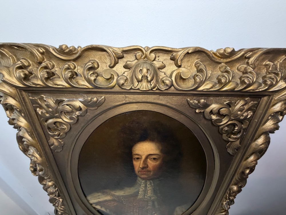 An 18th-century oil painting depicting King William III in a curled wig and ermine cloak, set within an oval aperture inside an ornate rectangular gold carved frame. View V