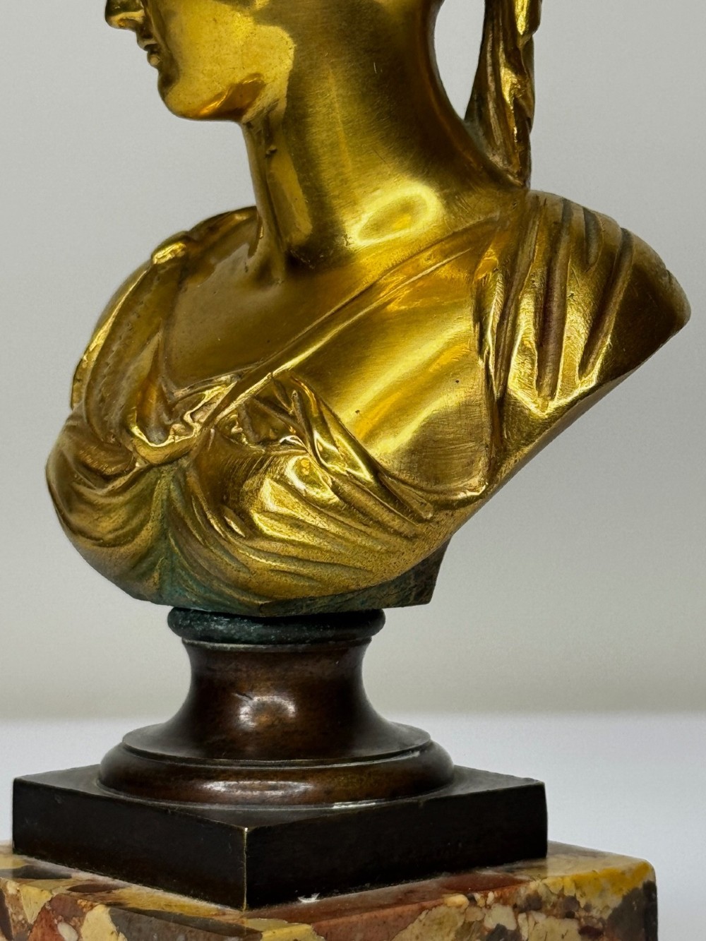 A 19th-century gilt bronze bust portrait of Diana de Poitiers featuring an ornate hairstyle and classical drapery, mounted on a dark socle and square variegated marble base. View IV