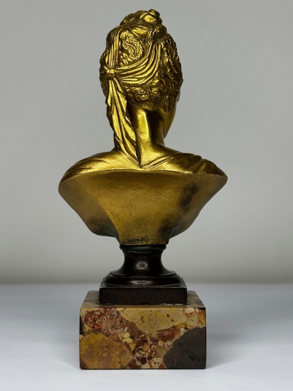 A 19th-century gilt bronze bust portrait of Diana de Poitiers featuring an ornate hairstyle and classical drapery, mounted on a dark socle and square variegated marble base. View VI