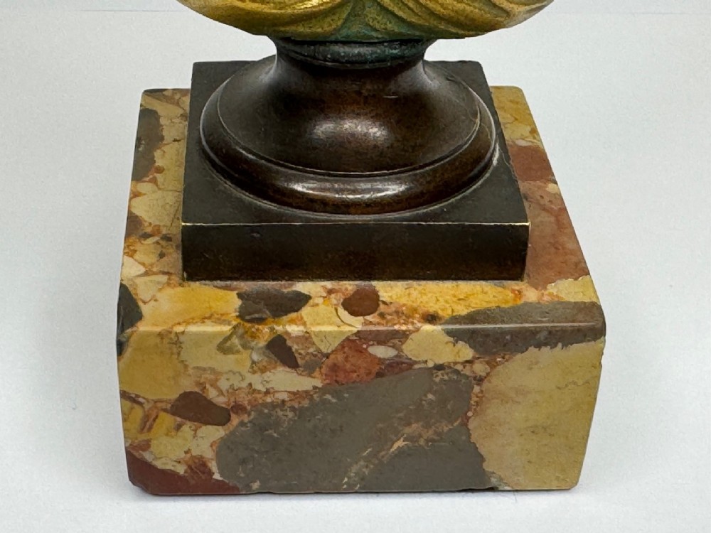 A 19th-century gilt bronze bust portrait of Diana de Poitiers featuring an ornate hairstyle and classical drapery, mounted on a dark socle and square variegated marble base. View X