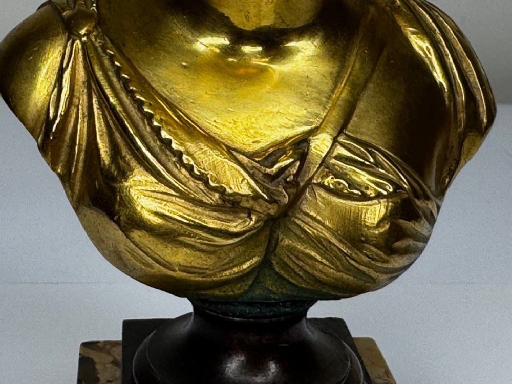 A 19th-century gilt bronze bust portrait of Diana de Poitiers featuring an ornate hairstyle and classical drapery, mounted on a dark socle and square variegated marble base. View XV
