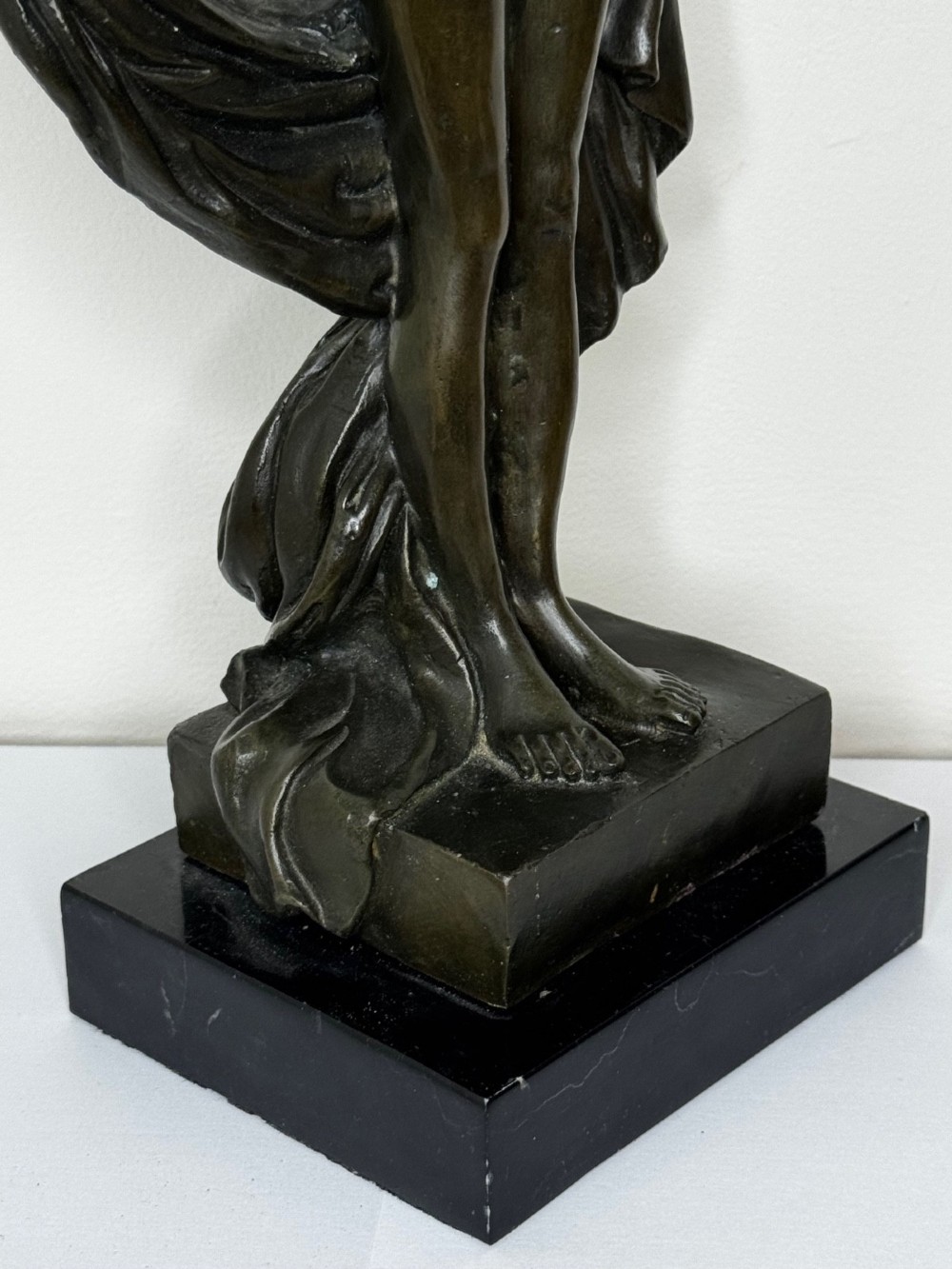 A dark brown patinated French bronze sculpture depicting a standing female nude draped in flowing fabric, mounted on a dark marble base. View II