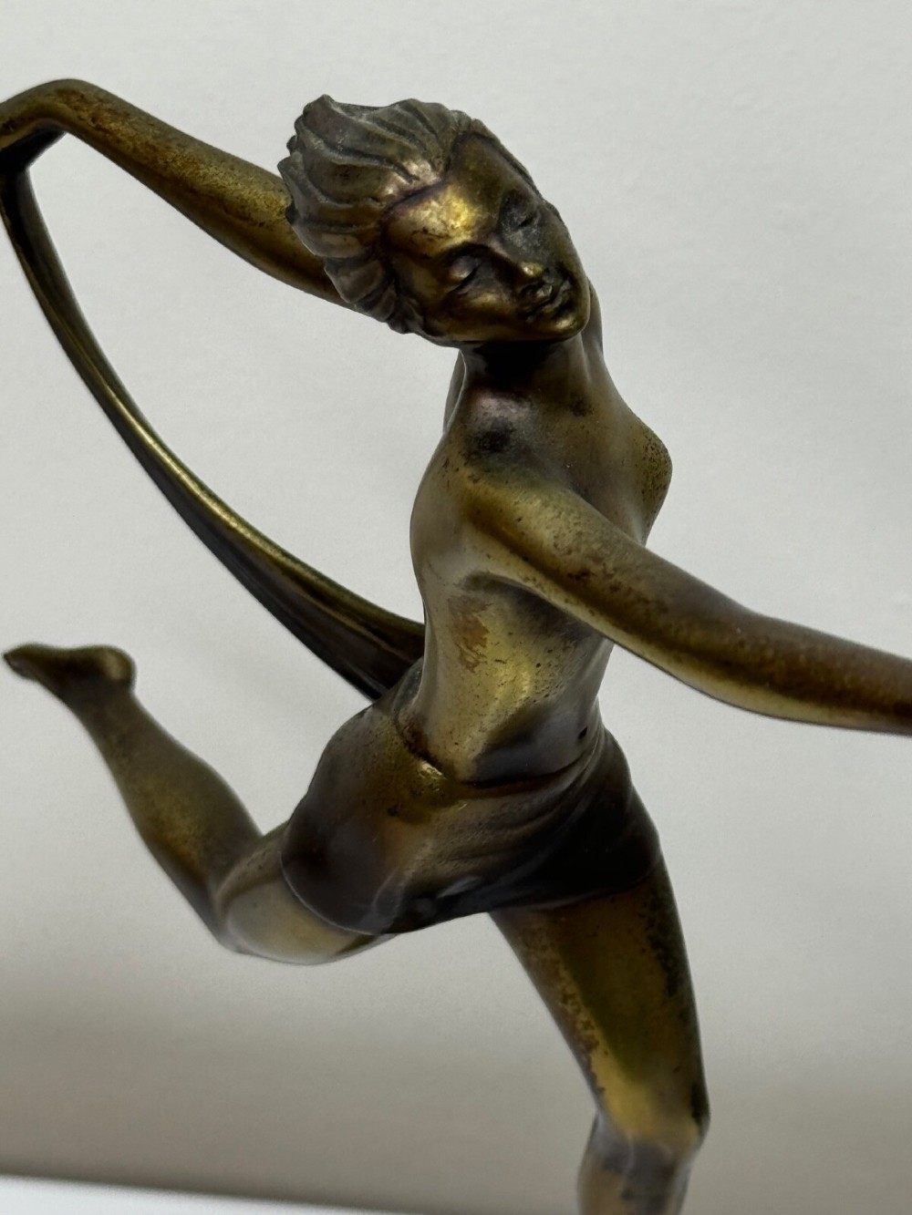 An Art Deco bronze sculpture depicting a dancer with draped fabric, mounted on a green onyx pedestal base. View X