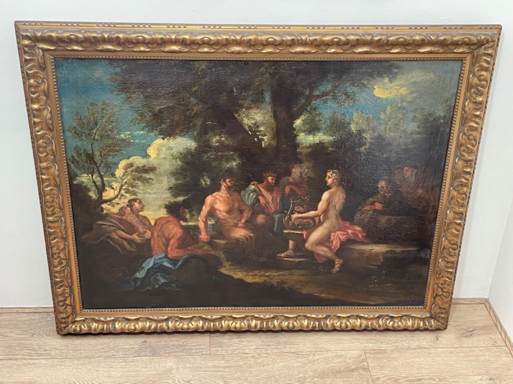 An 18th-century oil painting depicting classical figures in a wooded landscape, housed inside a carved gold giltwood frame. View XII