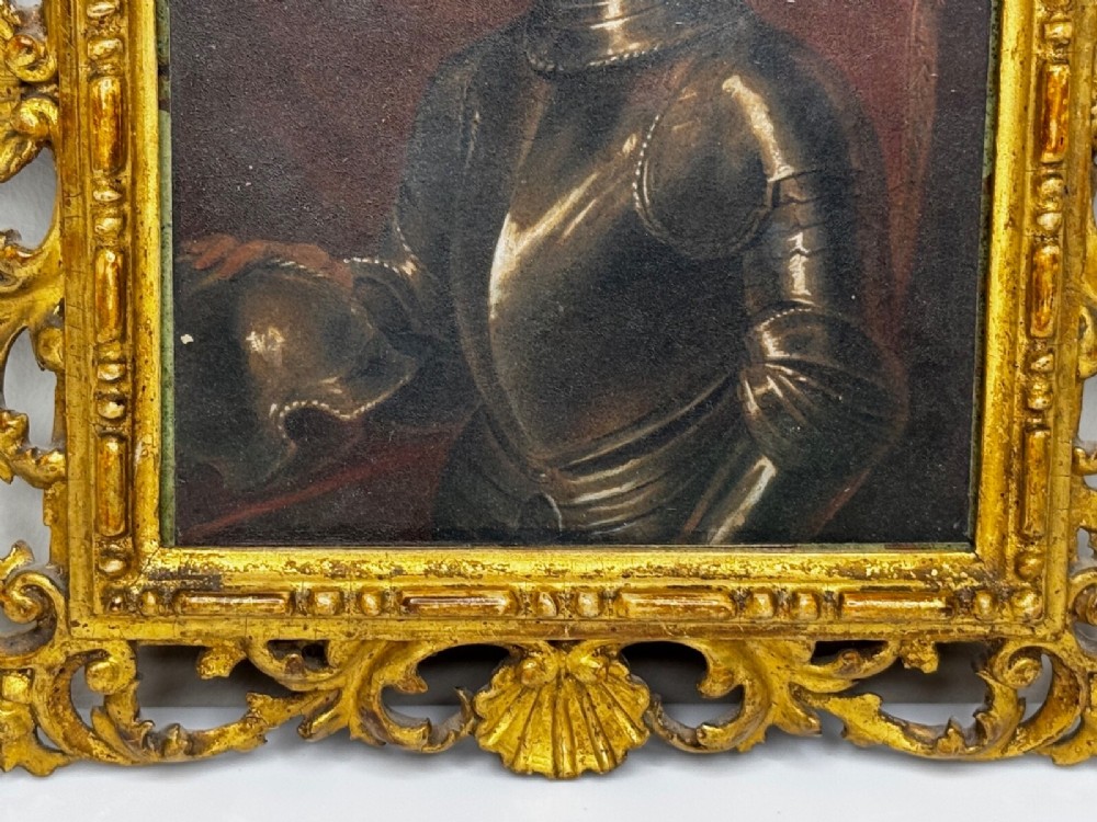 An antique profile portrait painting of a man wearing full steel armour, set within an ornate gilded frame decorated with carved shell and scroll motifs. View VII