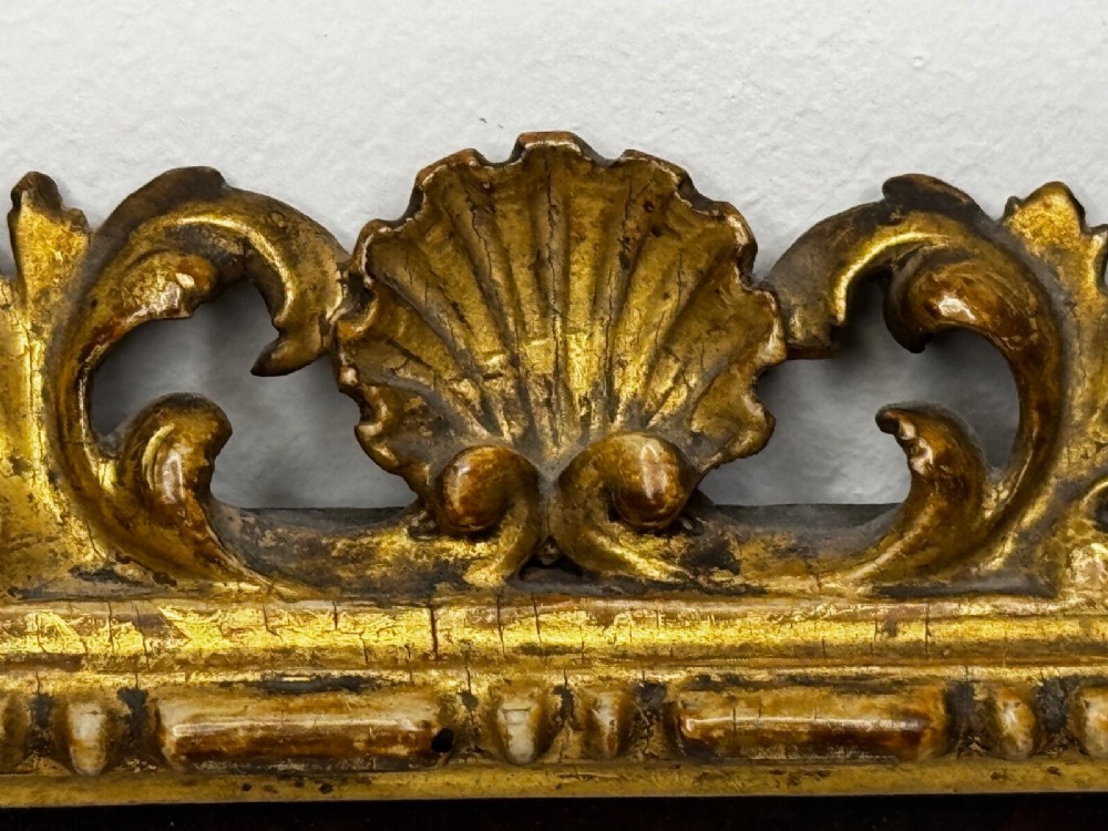 An antique profile portrait painting of a man wearing full steel armour, set within an ornate gilded frame decorated with carved shell and scroll motifs. View IX