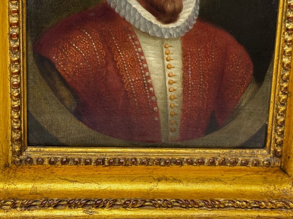 An 18th-century oil portrait of a man in a black hat, ruff collar, and crimson doublet set inside a carved gold-gilded frame. View XIII