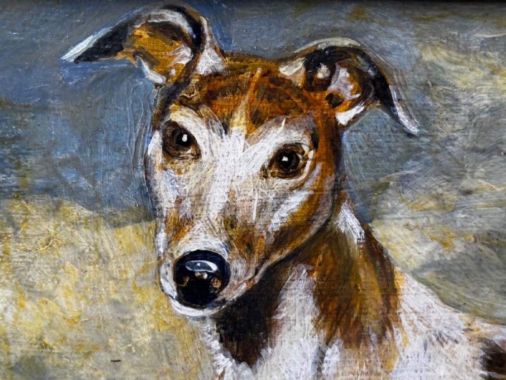 An antique Edwardian oil painting depicting a tan and white lurcher dog in a landscape, set within an ornate gilded frame. View IV