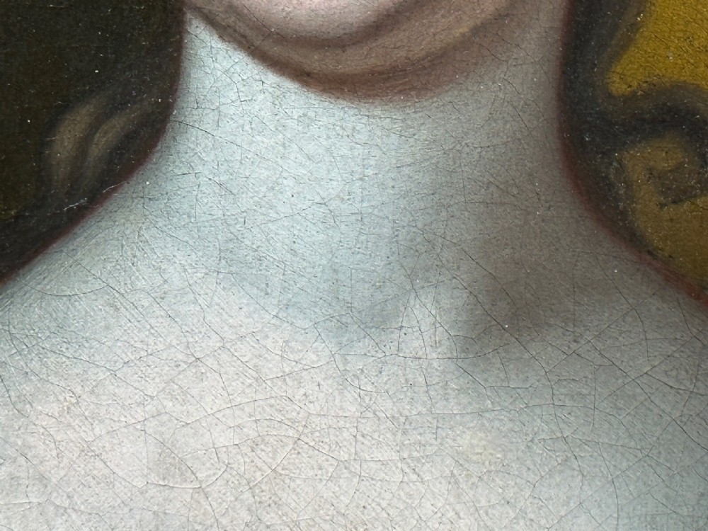 An early 18th-century oil portrait of a young woman wearing a dark gown with slashed sleeves, presented in a square giltwood frame with an oval spandrel. View XII