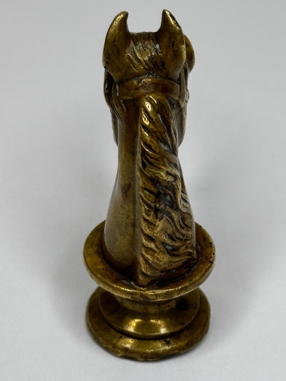 A cast brass Georgian desk seal sculpted in the shape of a detailed horse head above a rounded pedestal with an engraved intaglio base. View IX