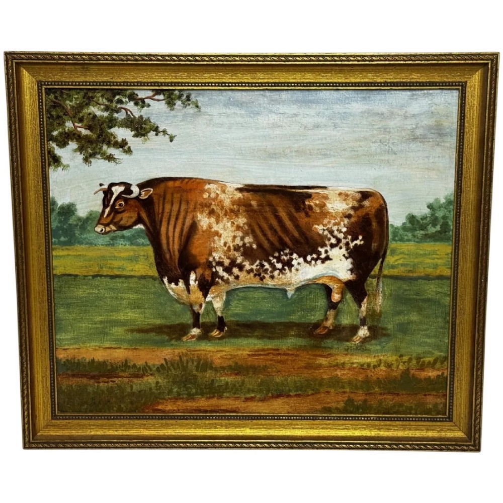 An antique Victorian oil painting depicting a brown and white shorthorn bull in a grassy field within a gilded frame.