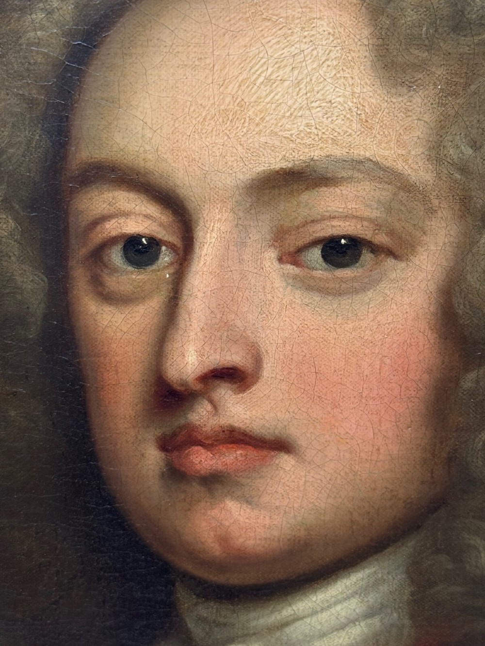 An 18th-century oil portrait depicting a gentleman in a red military coat and long curly wig, presented in a carved gold-leaf frame. View XIII