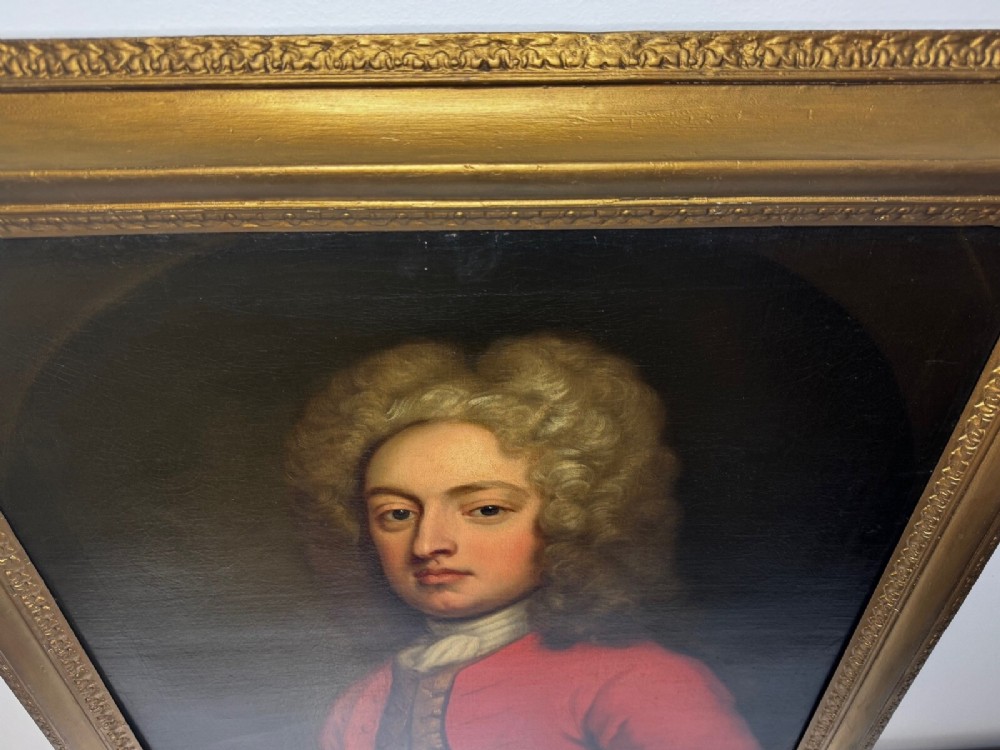 An 18th-century oil portrait depicting a gentleman in a red military coat and long curly wig, presented in a carved gold-leaf frame. View XIV