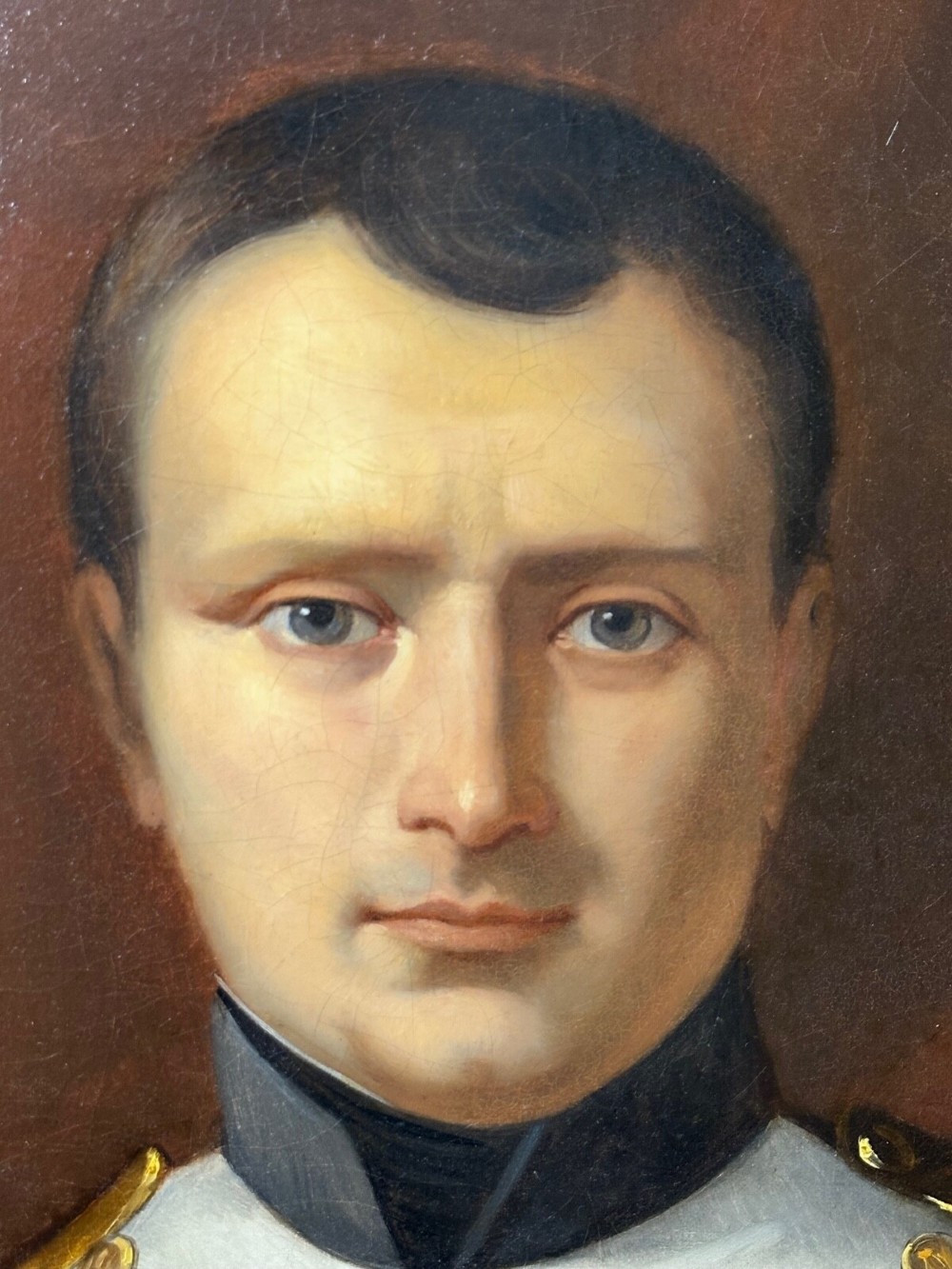 A 19th-century oil painting depicting Napoleon I in a military uniform within an oval spandrel and a rectangular gilded frame. View XV
