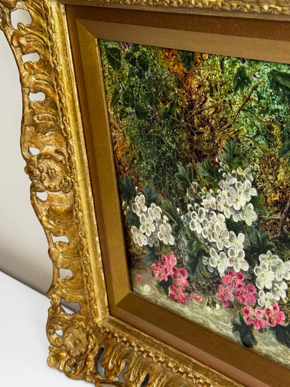 A Victorian oil painting depicting white and pink blossoms alongside a bird nest with three blue eggs, framed in an ornate pierced gold leaf frame. View XI