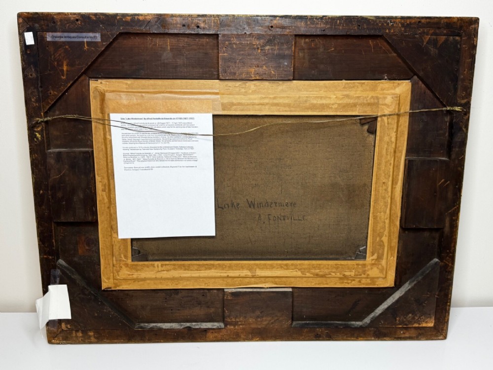 An antique oil painting depicting a lake surrounded by mountains at sunset, enclosed within a carved gold frame. View III