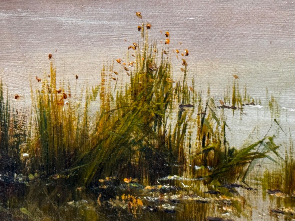 An antique oil painting depicting a lake surrounded by mountains at sunset, enclosed within a carved gold frame. View VI