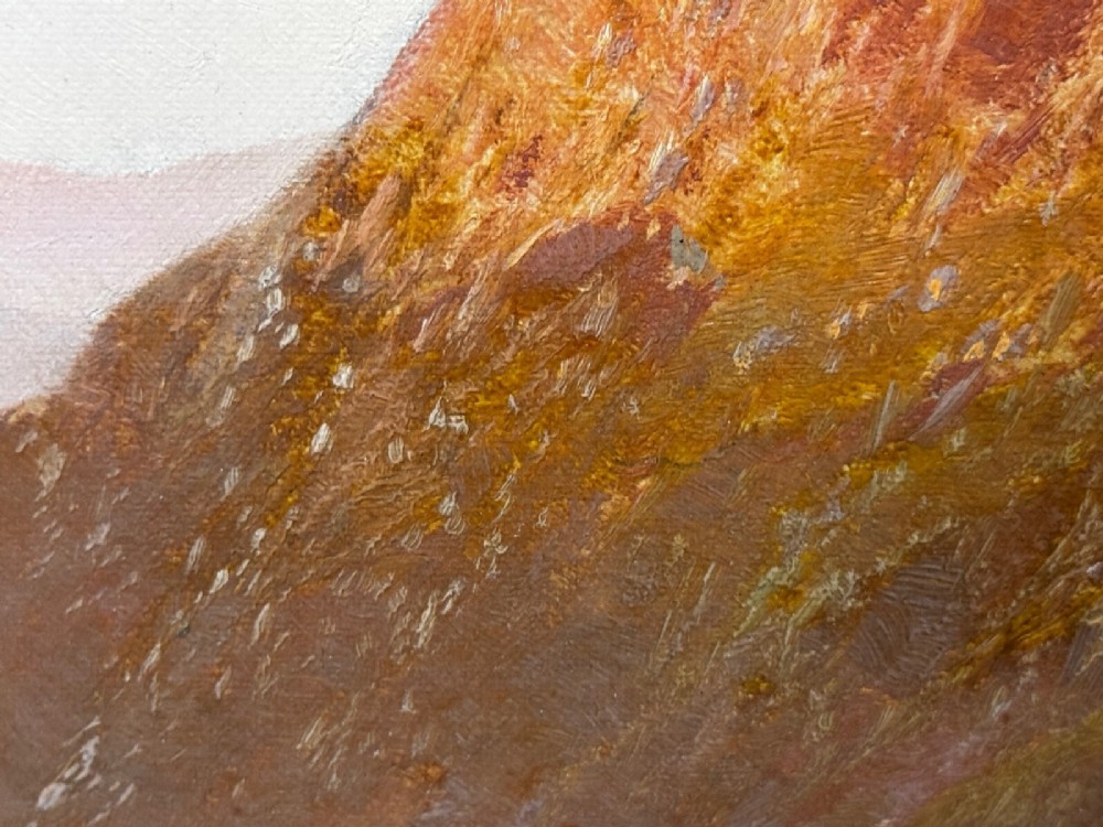An antique oil painting depicting a lake surrounded by mountains at sunset, enclosed within a carved gold frame. View IX