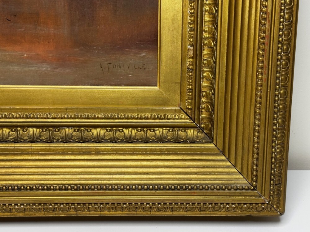 An antique oil painting depicting a lake surrounded by mountains at sunset, enclosed within a carved gold frame. View XII