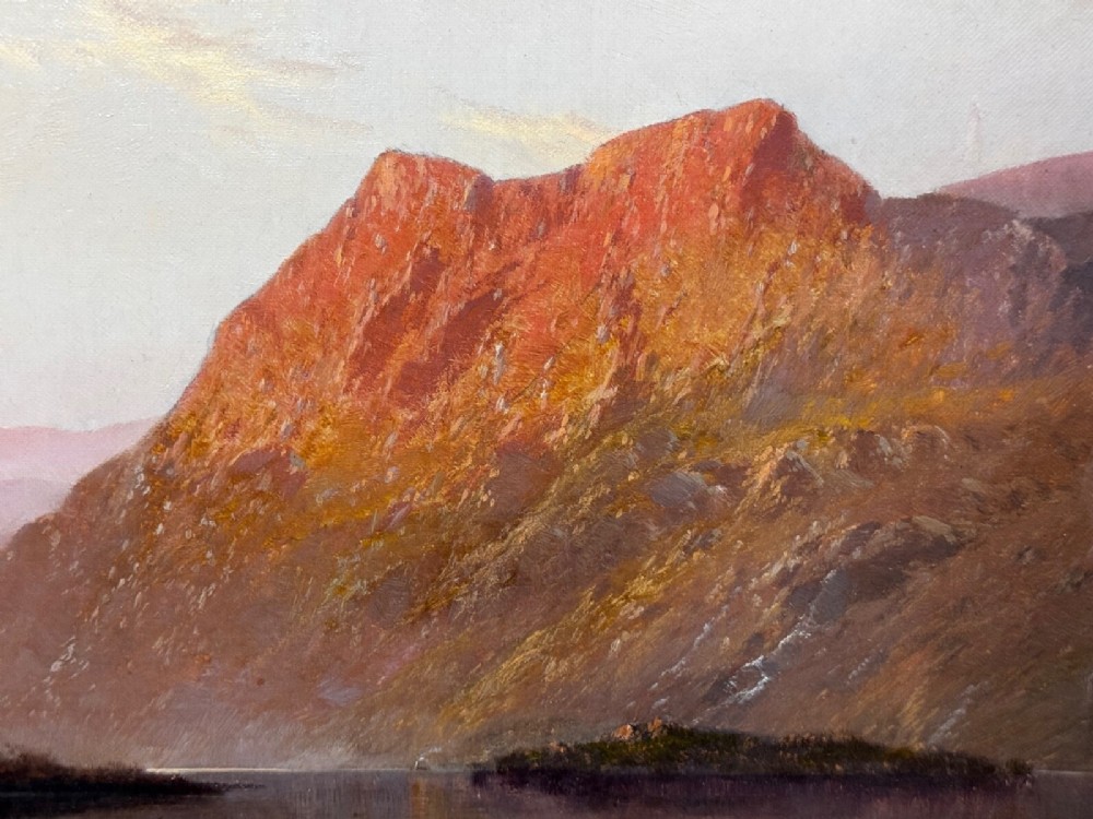 An antique oil painting depicting a lake surrounded by mountains at sunset, enclosed within a carved gold frame. View XIV
