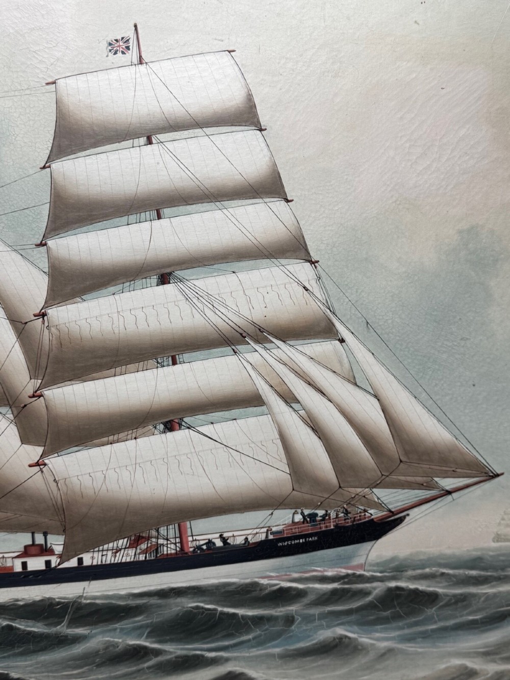 A framed oil painting depicting a three-masted sailing ship navigating dark blue seas under a cloudy sky within a gold gilt frame. View XIII