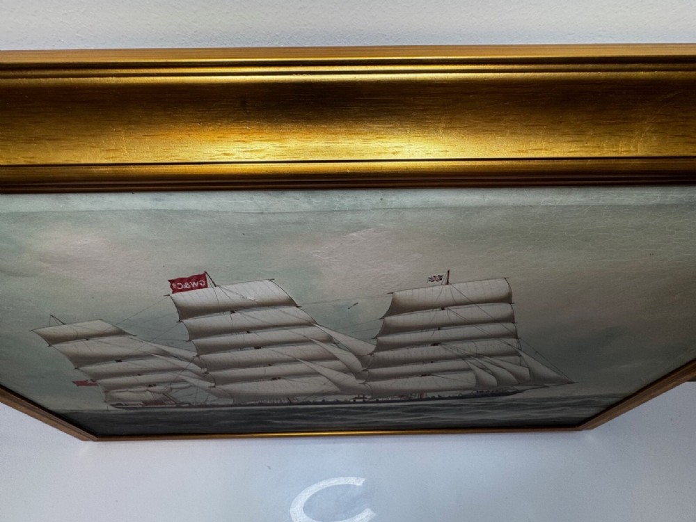 A framed oil painting depicting a three-masted sailing ship navigating dark blue seas under a cloudy sky within a gold gilt frame. View XIV