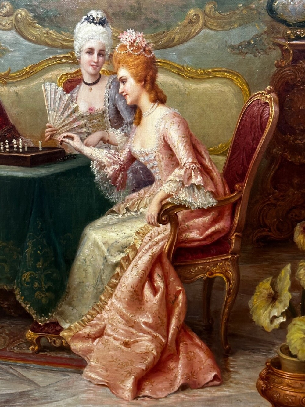 An 19th-century framed oil painting depicting figures in period attire gathered around a table engaged in a game of chess. View III