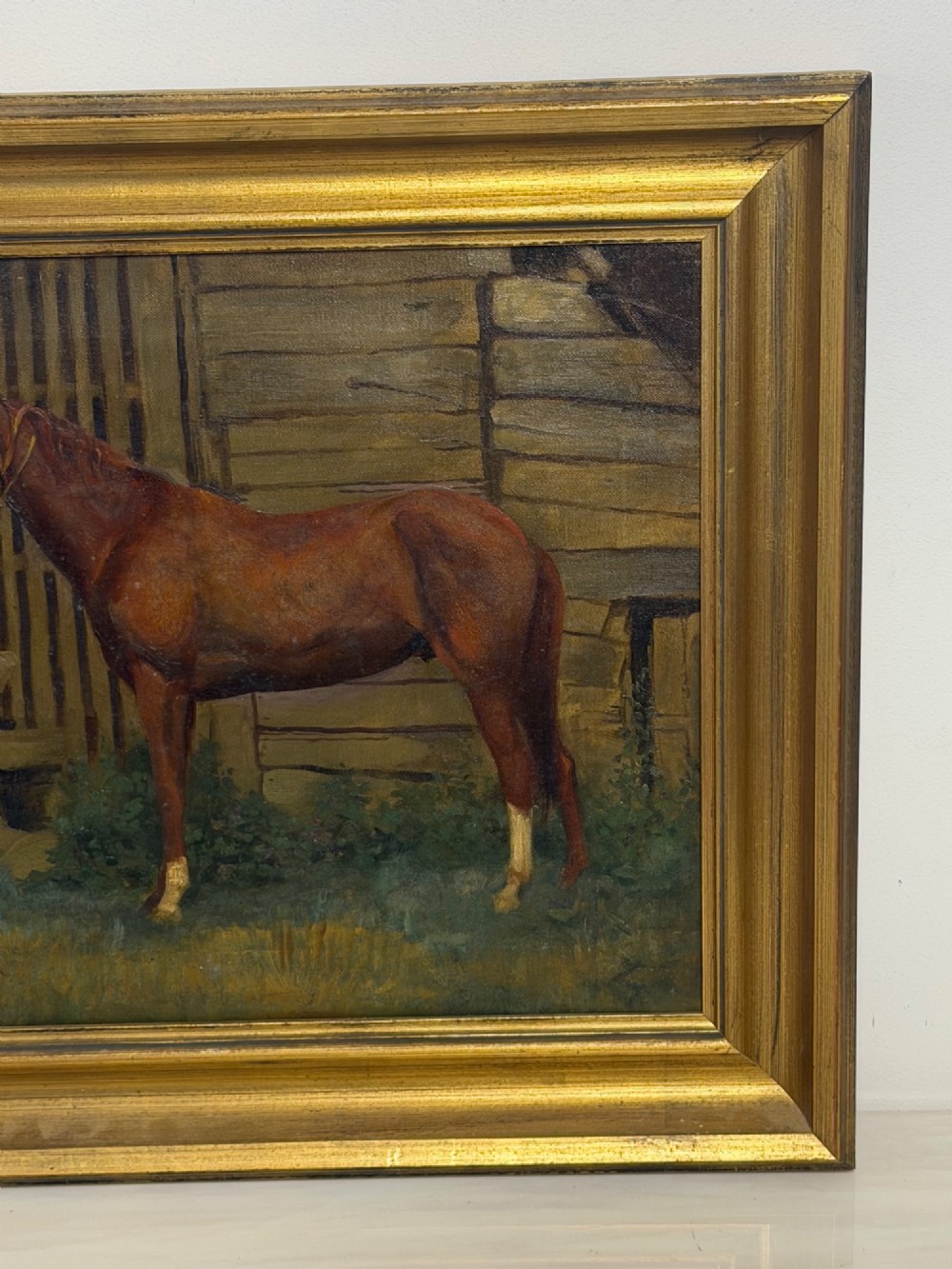 A framed oil painting depicting a brown horse standing in profile in front of a weathered wooden barn structure. View II