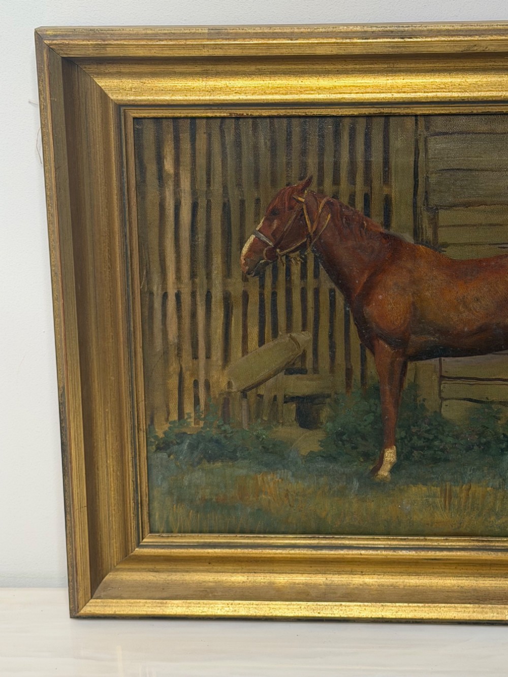A framed oil painting depicting a brown horse standing in profile in front of a weathered wooden barn structure. View III