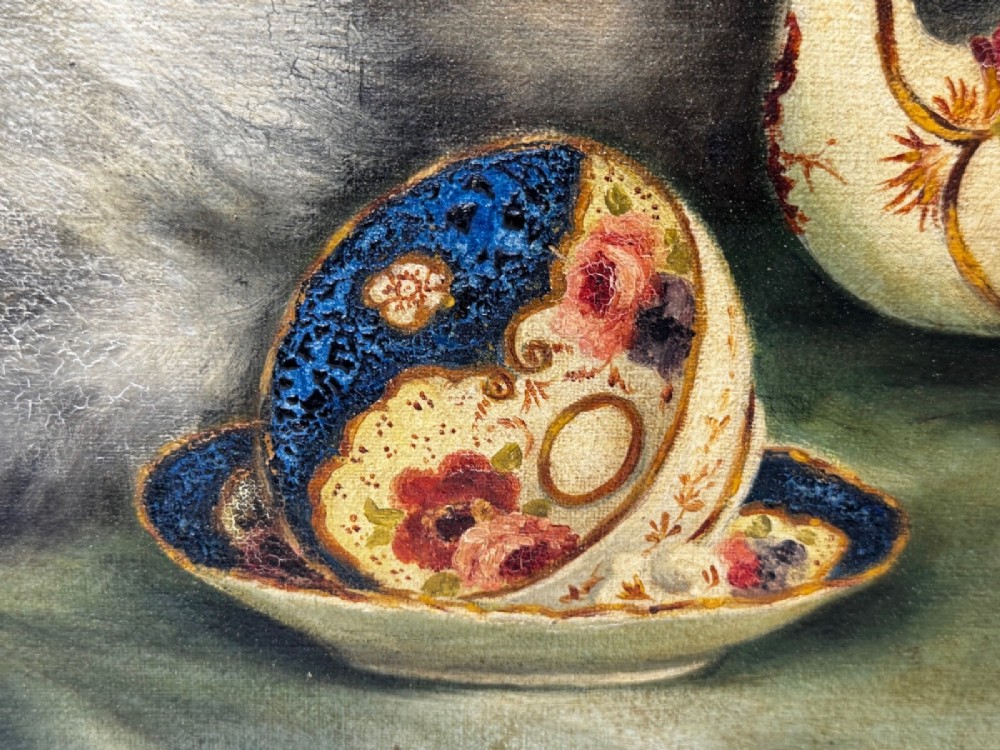 An antique framed oil painting depicting five grey and cream Persian kittens positioned around a wicker basket and a floral porcelain teapot. View VI