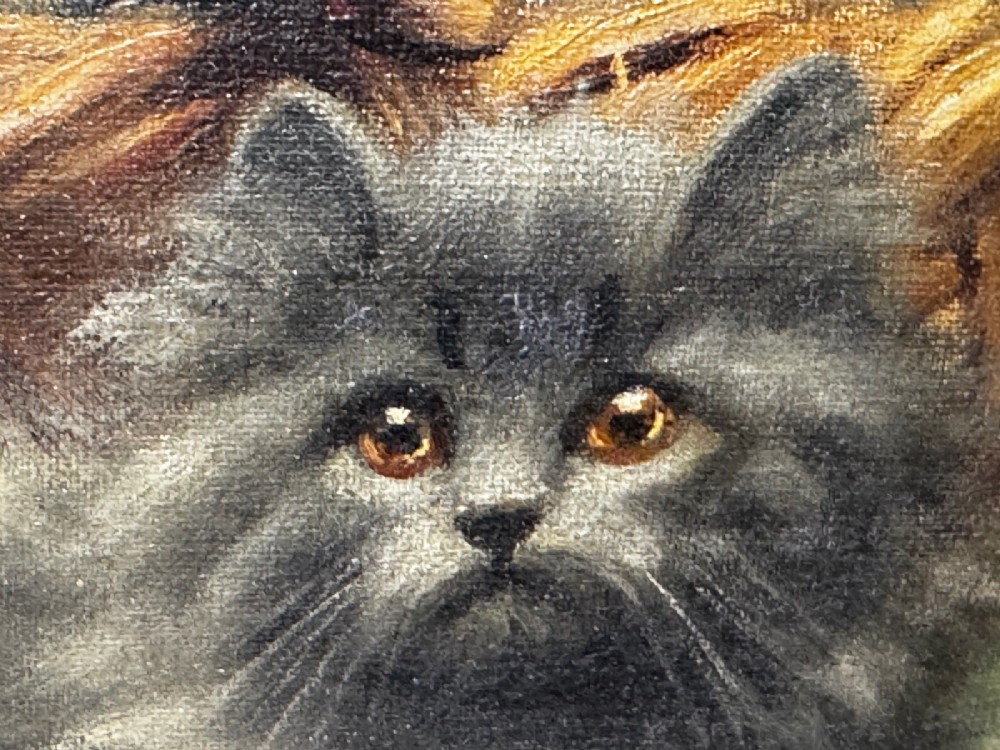 An antique framed oil painting depicting five grey and cream Persian kittens positioned around a wicker basket and a floral porcelain teapot. View XIV
