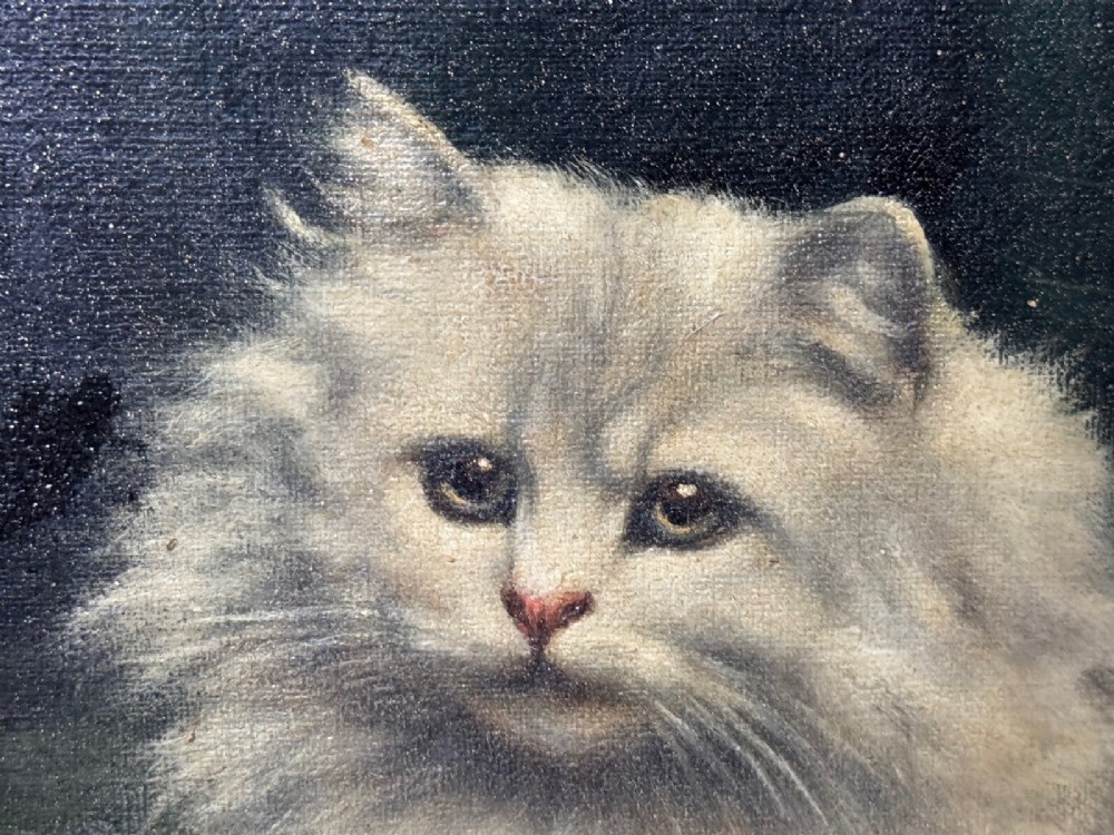 An antique framed oil painting depicting five grey and cream Persian kittens positioned around a wicker basket and a floral porcelain teapot. View XV