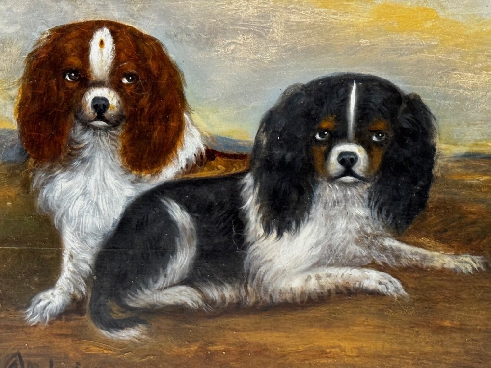 A nineteenth-century framed oil painting depicting a Blenheim spaniel and a tricolour spaniel seated outdoors, enclosed within an ornate gold giltwood frame. View II
