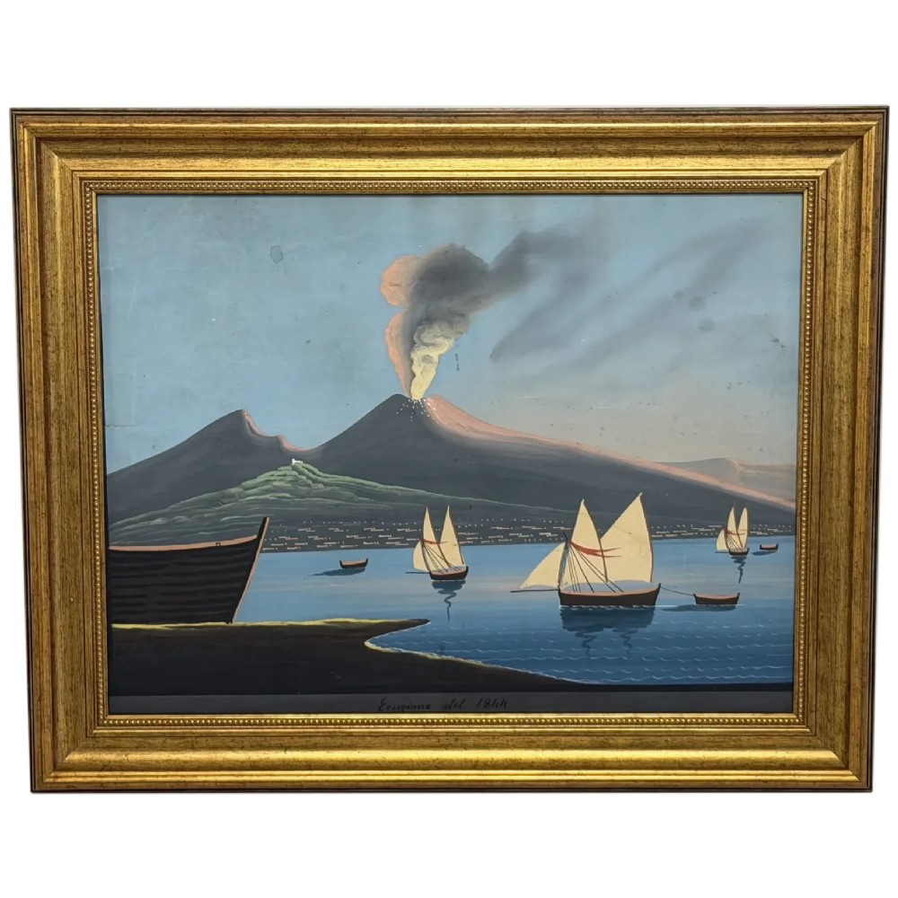 A framed 19th-century gouache painting depicting the eruption of Mount Vesuvius over the Bay of Naples with sailboats in the foreground.