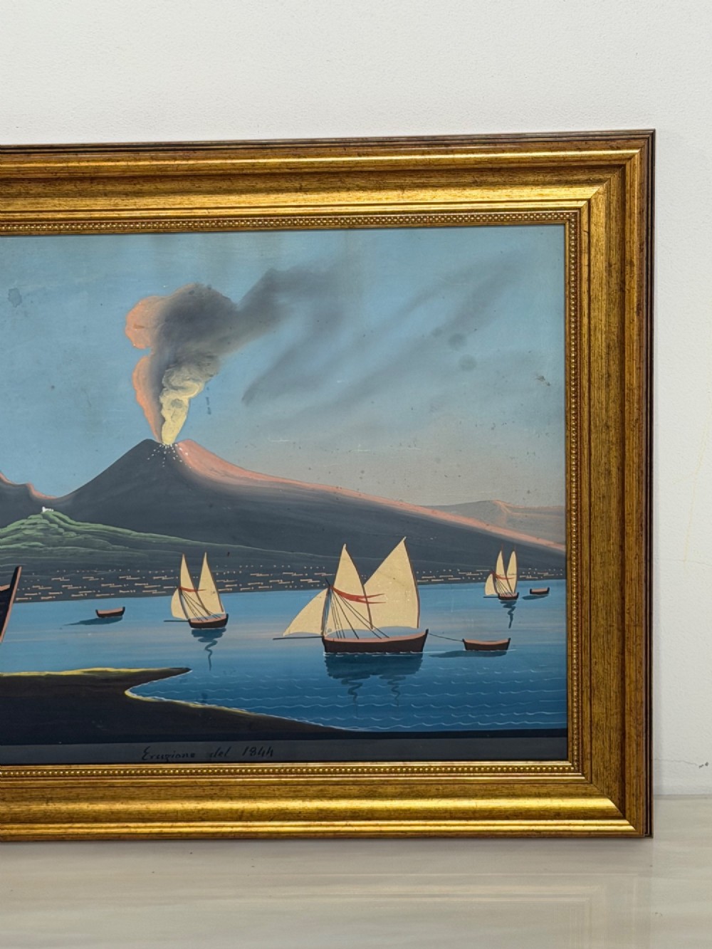 A framed 19th-century gouache painting depicting the eruption of Mount Vesuvius over the Bay of Naples with sailboats in the foreground. View II