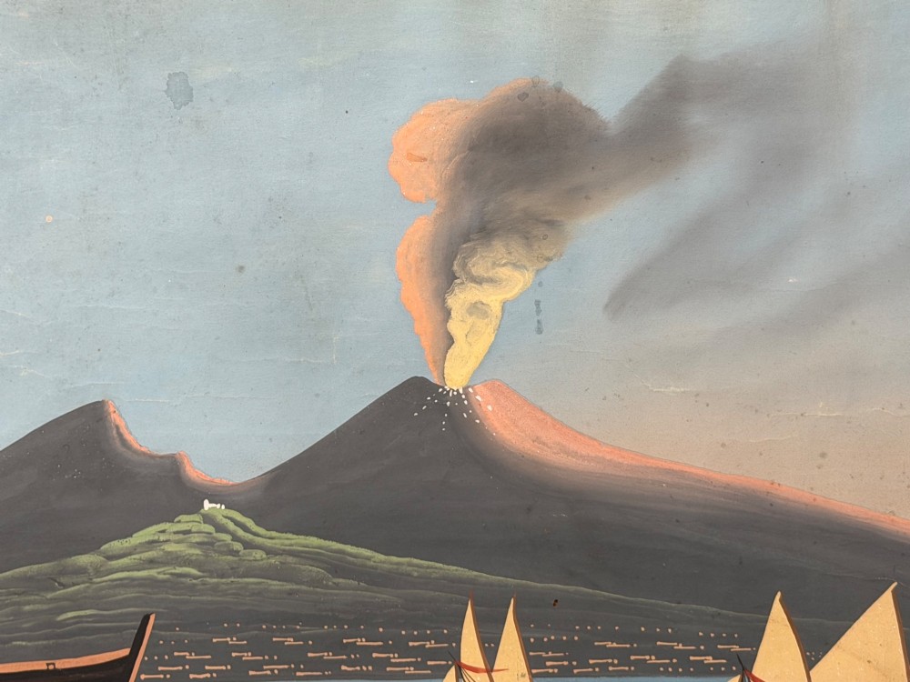 A framed 19th-century gouache painting depicting the eruption of Mount Vesuvius over the Bay of Naples with sailboats in the foreground. View IX
