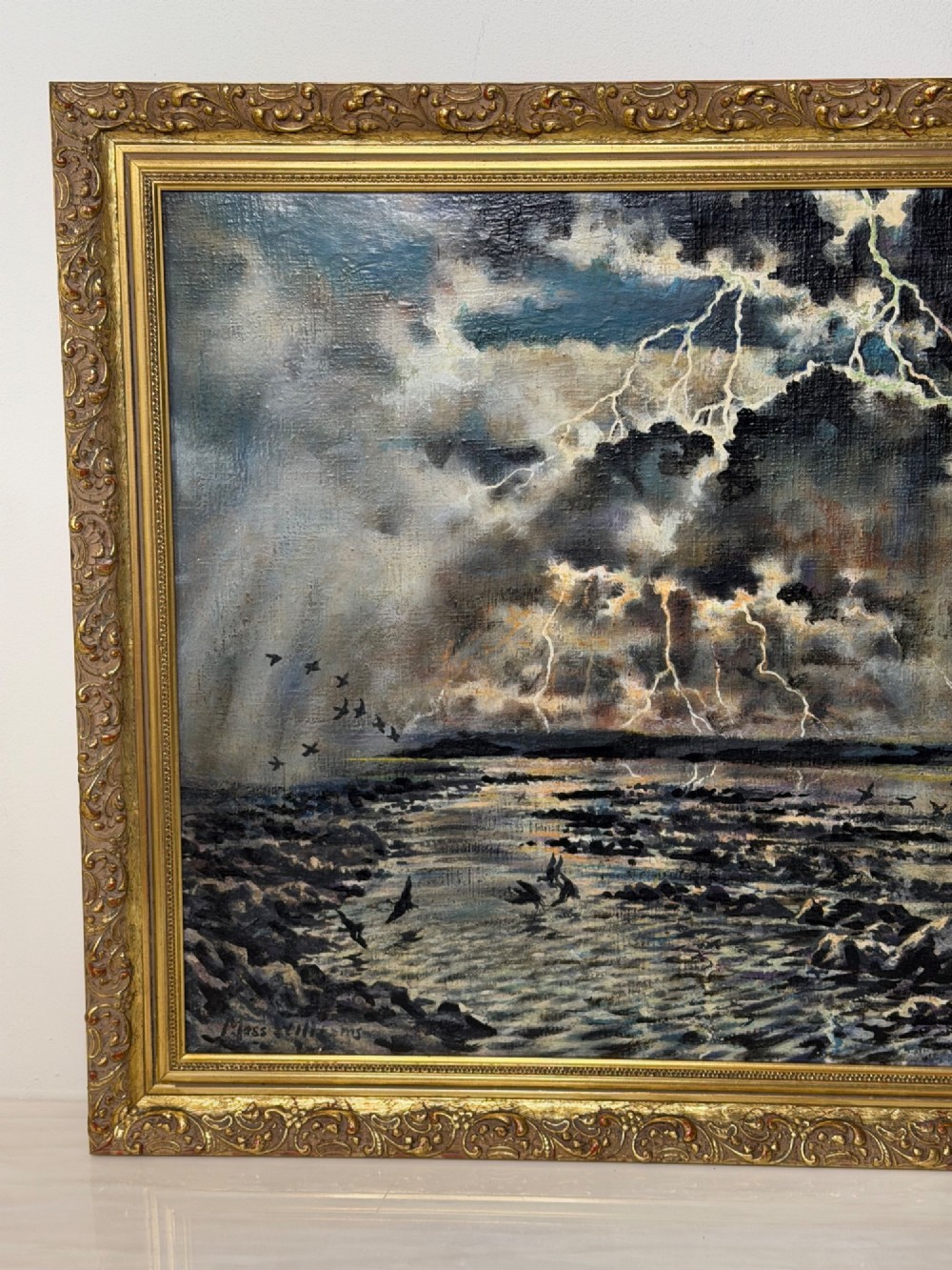 A framed oil painting depicting a lightning storm over a rocky coastal bay with birds flying near the water surface. View III