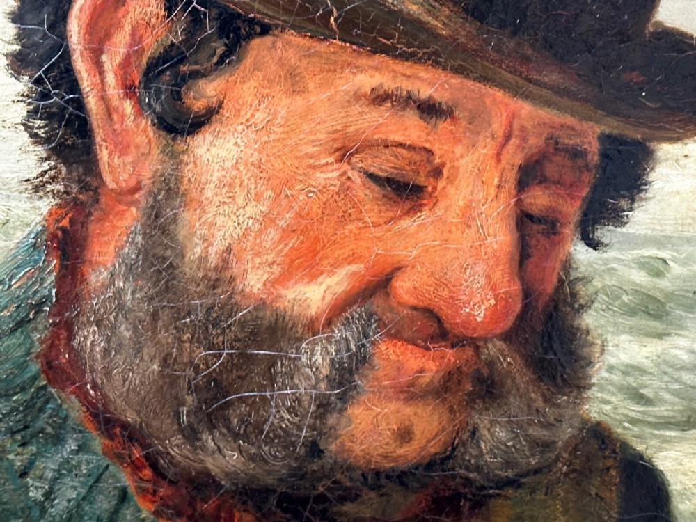 An antique oil painting depicting a bearded fisherman in a green knitted jumper sitting in a boat with his catch, encased in a dark wooden frame. View VIII