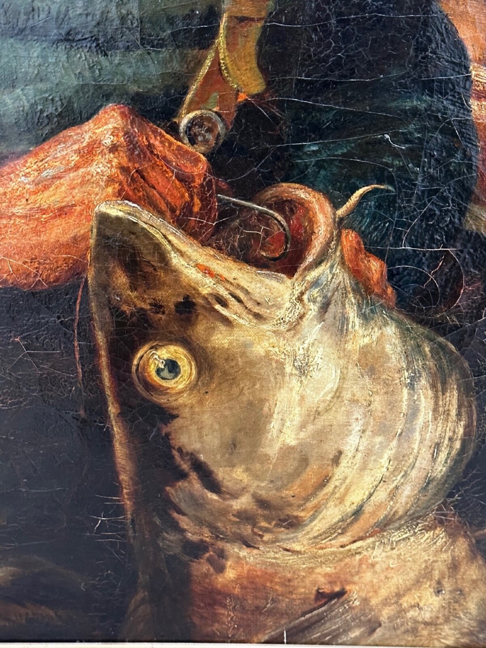 An antique oil painting depicting a bearded fisherman in a green knitted jumper sitting in a boat with his catch, encased in a dark wooden frame. View XII