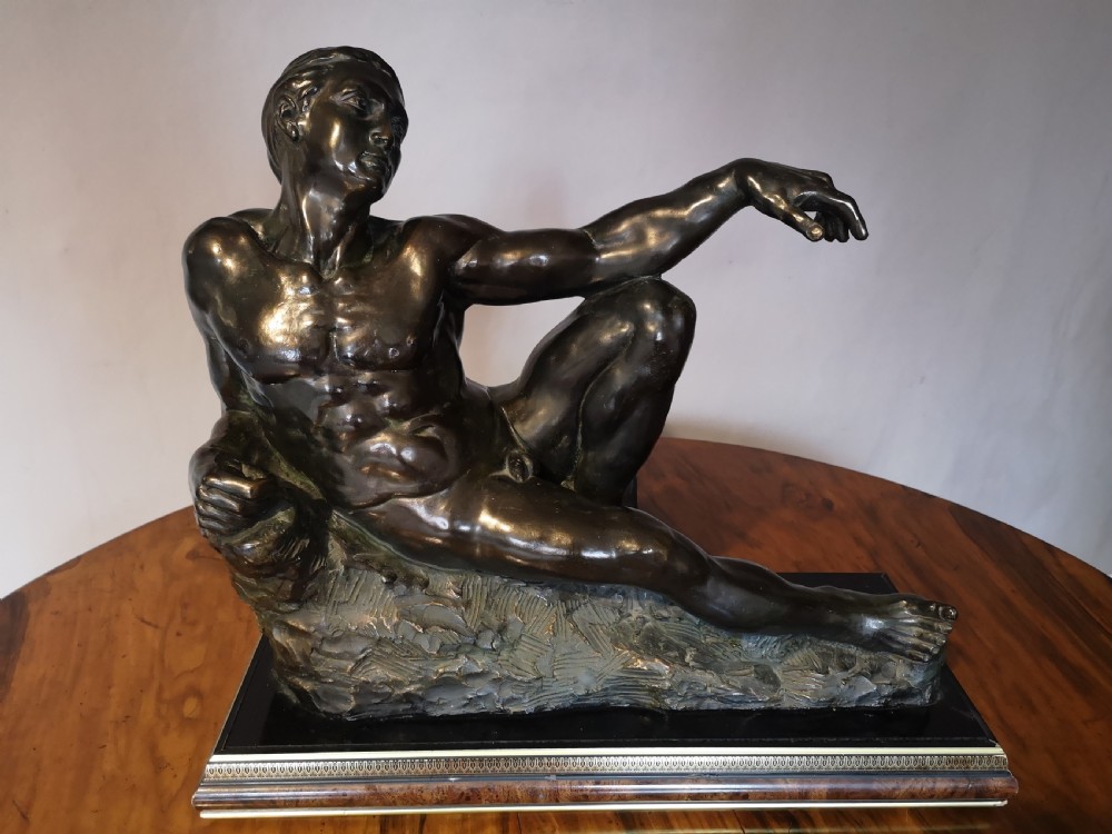 Patinated bronze sculpture of a reclining male nude