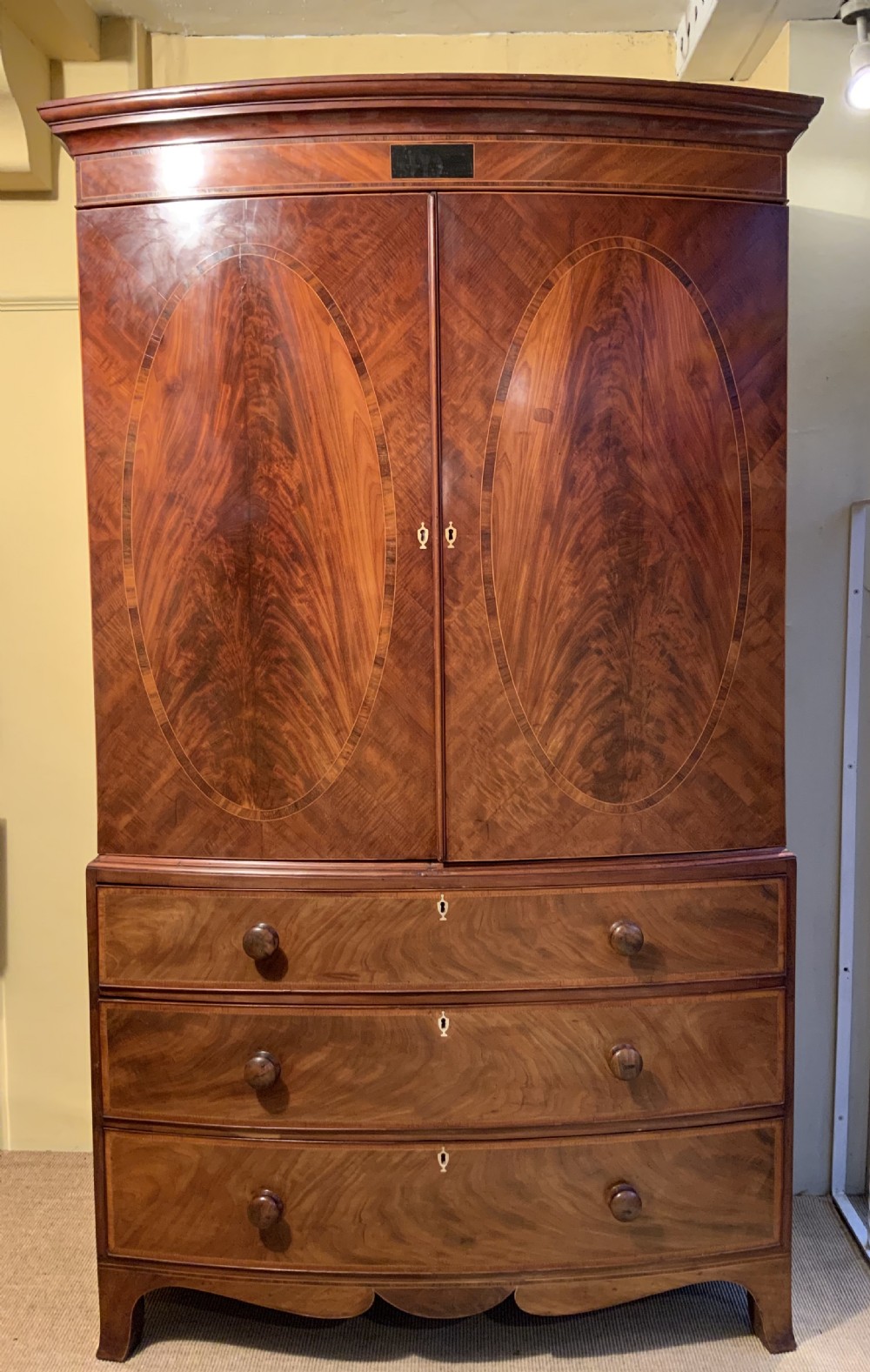 A  Georgian bow front mahogany linen press