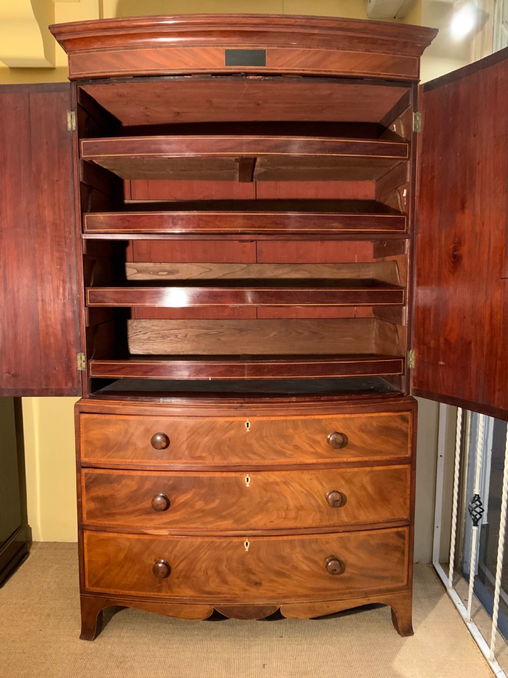A  Georgian bow front mahogany linen press View V