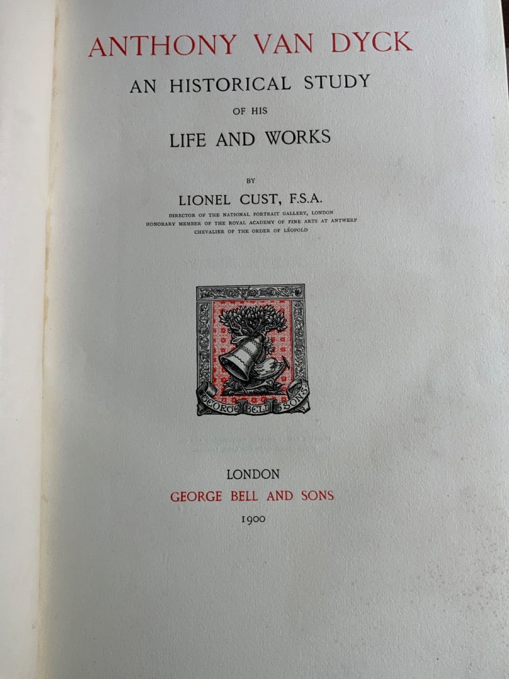 A large tan leather-bound antique book featuring ornate gold gilt tooling on the spine and front cover. View VIII
