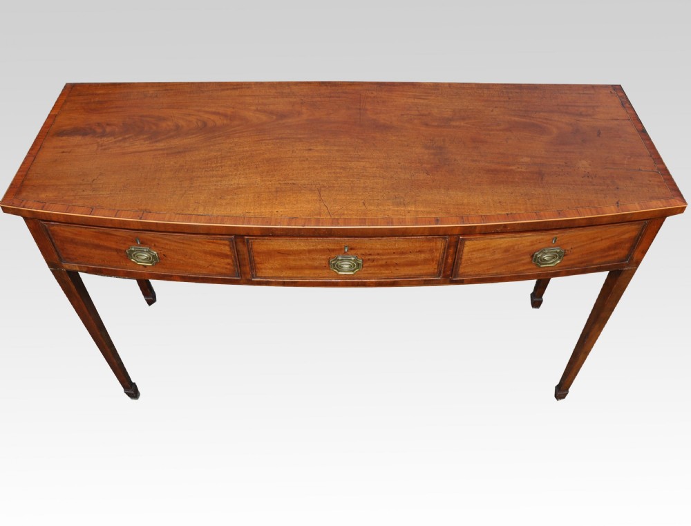 A George III mahogany bow fronted three drawer side table View VI