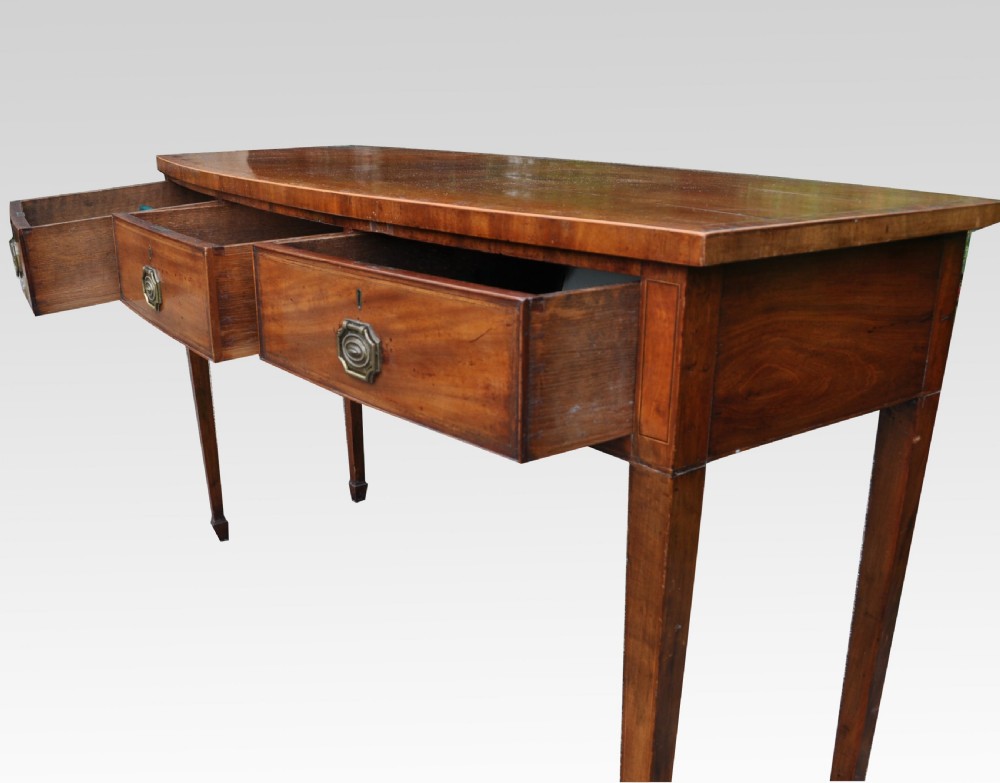 A George III mahogany bow fronted three drawer side table View VII
